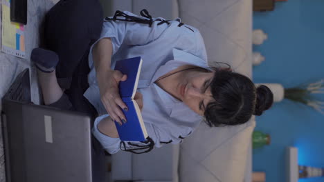 Vertical-video-of-Home-office-worker-woman-reading-a-book.